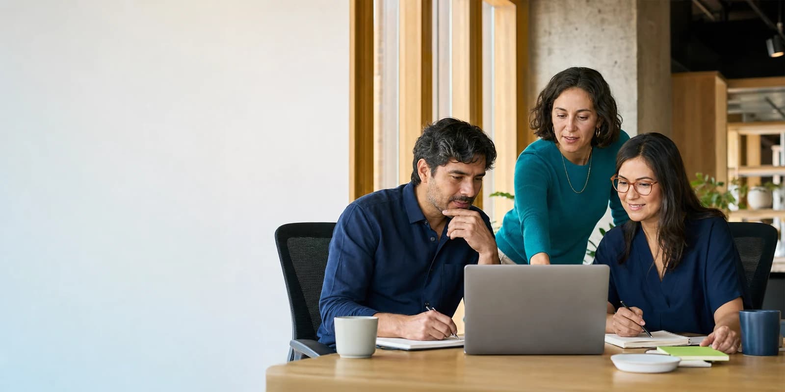 Tres profesionales trabajan juntos frente a un computador mientras practican una tarea real con acompañamiento.